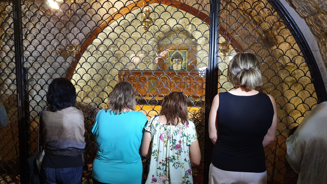 A group of people praying in front of The Tomb of Saint Sharbel in Annaya, Lebanon. 