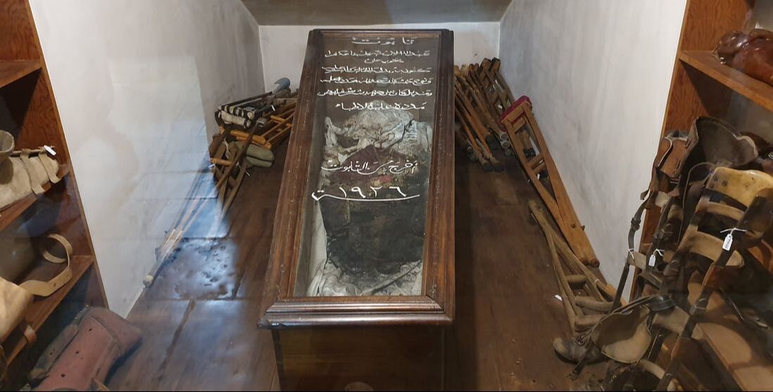 One of Saint Sharbel’s old coffins, surrounded by crutches and other aid objects used by healed people.