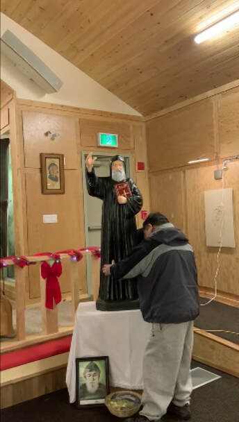 a man Installs installing Statue of Saint Sharbel in Church
